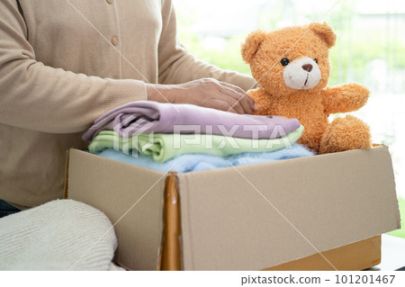 Donation box with used clothes and doll at home to support help for poor people in the world. Donation box with used clothes and doll at home to support help for poor people in the world. 101201467