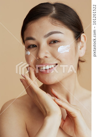 Portrait of modern woman with facial cream on face Portrait of modern woman with facial cream on face 101201522