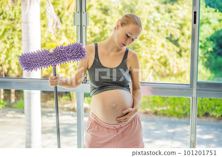 Pregnant woman washes the floor and is tired. Tired pregnant woman having pain in back while she is cleaning her house Pregnant woman washes the floor and is tired. Tired pregnant woman having pain in back while she is cleaning her house 101201751