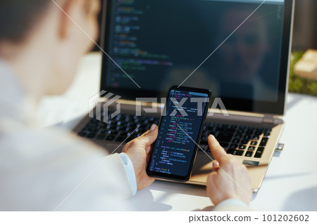 Seen from behind modern woman with laptop developing program Seen from behind modern woman with laptop developing program 101202602