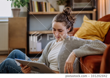 Young woman with digital tablet resting in her apartment. Young woman with digital tablet resting in her apartment. 101202842