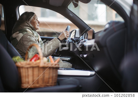 Senior woman driving a car,retourning from grocery store. Senior woman driving a car,retourning from grocery store. 101202858