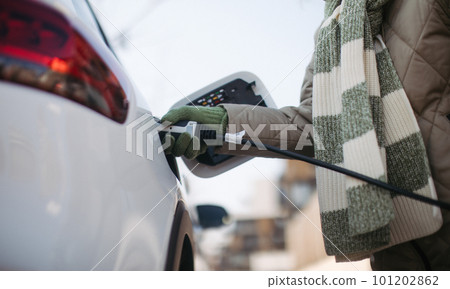 Close up of urecognizable person charging electric car. 101202862