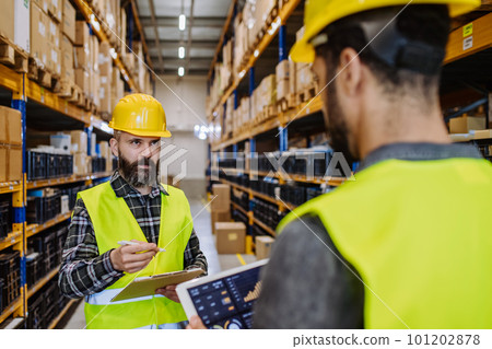 Warehouse workers checking stuff in warehouse with digital system in tablet. 101202878
