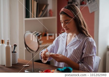 Teenage girl doing her skin care routine. Teenage girl doing her skin care routine. 101202940