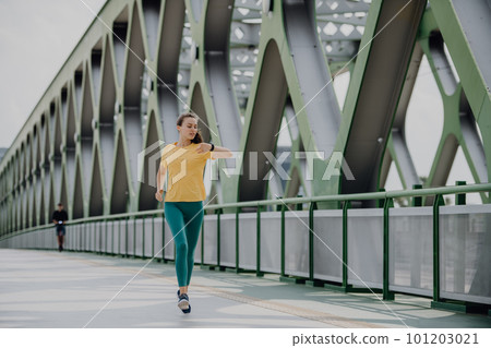 Young woman jogging at city bridge, healthy lifestyle and sport concept. 101203021
