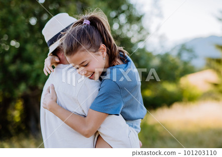 Father hugging his daughter in summer in nature. Father's day concept. 101203110