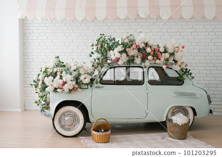 Retro mint car decorated with flowers in the photo zone in a romantic style for Spring Day or St. Valentine Retro mint car decorated with flowers in the photo zone in a romantic style for Spring Day or St. Valentine 101203295