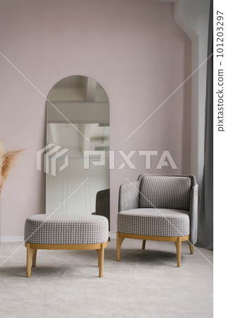 Classic modern grey armchairs, an ottoman in the living room interior and a mirror 101203297