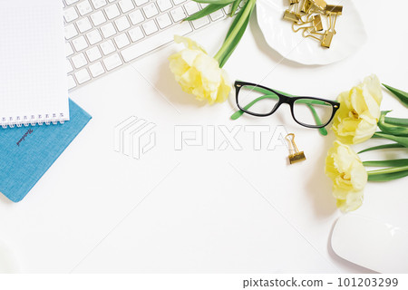 Home office clipboard desk with copy space, clipboard, pen, glasses, notepad and paper clips and tulip flowers on a white background. Flat layout, workspace layout, top view. 101203299