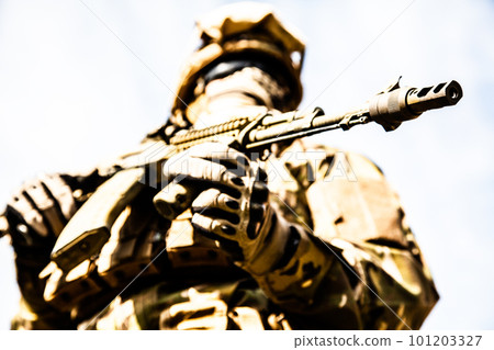 A low angle shot of a military soldier with weapons A low angle shot of a military soldier with weapons 101203327