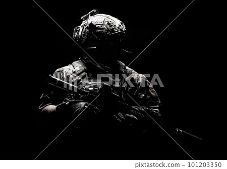 Modern army special forces equipped soldier, anti terrorist squad fighter, elite mercenary in helmet, studio portrait in darkness. Close up, half length 101203350