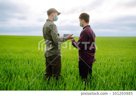 Two Farmers in protection mask with tablet in the field. Modern agriculture technology.Smart farming 101203985
