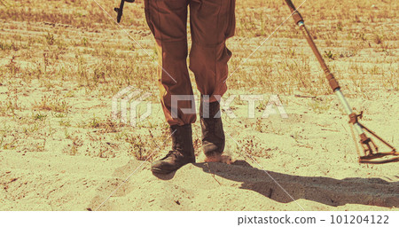 Soviet Army Sapper combat engineer deminer with a mine detector in his hands is looking for mines on the field. Bomb tech Bomb Squad In Historical Re-enactment of Soviet - Afghan War. 101204122