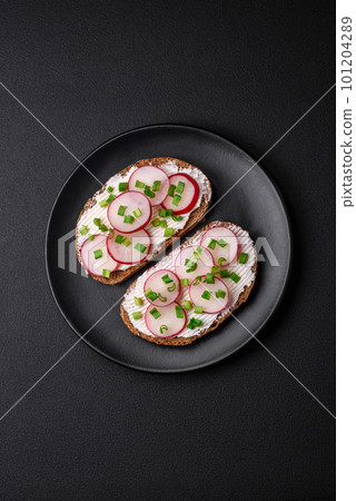 Delicious sandwich or bruschetta with cream cheese radish and green onions 101204289