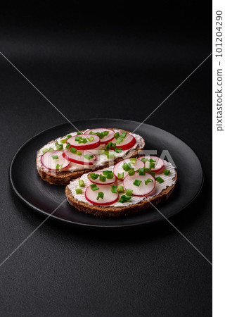 Delicious sandwich or bruschetta with cream cheese radish and green onions 101204290