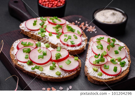 Delicious sandwich or bruschetta with cream cheese radish and green onions 101204296