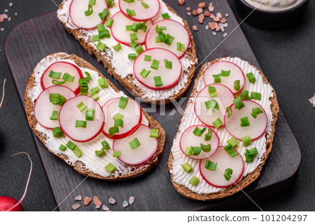 Delicious sandwich or bruschetta with cream cheese radish and green onions Delicious sandwich or bruschetta with cream cheese radish and green onions 101204297