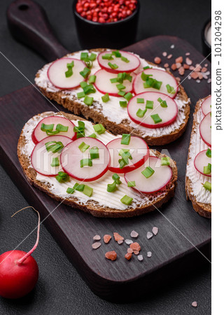 Delicious sandwich or bruschetta with cream cheese radish and green onions 101204298