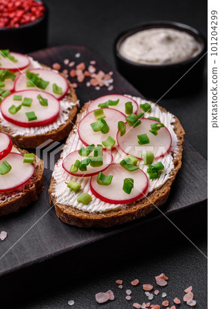 Delicious sandwich or bruschetta with cream cheese radish and green onions Delicious sandwich or bruschetta with cream cheese radish and green onions 101204299