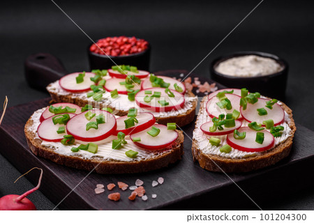 Delicious sandwich or bruschetta with cream cheese radish and green onions 101204300