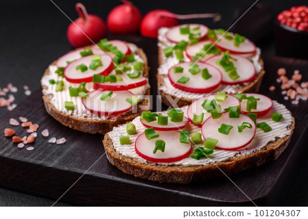 Delicious sandwich or bruschetta with cream cheese radish and green onions 101204307