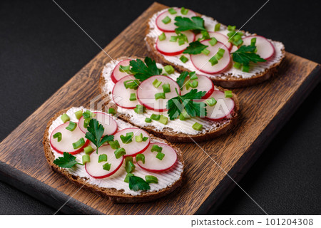 Delicious sandwich or bruschetta with cream cheese radish and green onions 101204308