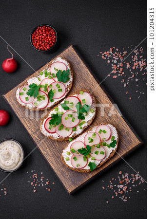 Delicious sandwich or bruschetta with cream cheese radish and green onions Delicious sandwich or bruschetta with cream cheese radish and green onions 101204315