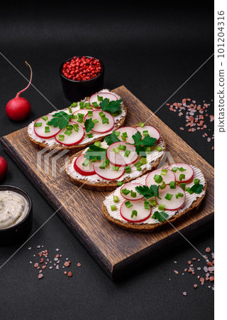 Delicious sandwich or bruschetta with cream cheese radish and green onions Delicious sandwich or bruschetta with cream cheese radish and green onions 101204316