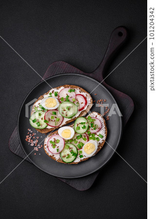 Delicious sandwich or bruschetta with cream cheese radish and green onions Delicious sandwich or bruschetta with cream cheese radish and green onions 101204342