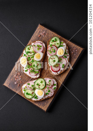 Delicious sandwich or bruschetta with cream cheese radish and green onions 101204354