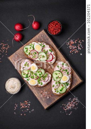 Delicious sandwich or bruschetta with cream cheese radish and green onions 101204371