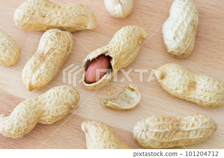 Variety of whole peanuts and one half peeled peanut with cracked shell Variety of whole peanuts and one half peeled peanut with cracked shell 101204712
