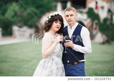 Bride and groom holding glasses with champagne and clink Bride and groom holding glasses with champagne and clink 101204791