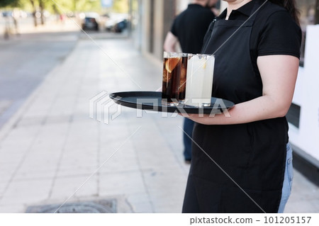 Unrecognizable waitress working on restaurant holding drink. latin woman worker hand 101205157