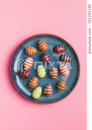 Chocolate easter eggs on plate on pink background. Top view. 101205190