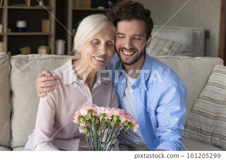 Cheerful young adult guy congratulating mom on 8 march 101205299