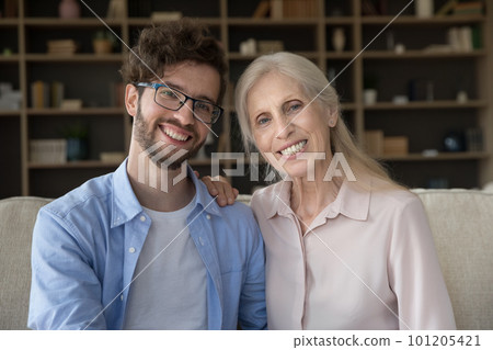 Cheerful handsome adult son and senior mom sitting close 101205421