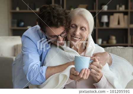 Loving young adult son giving positive sick senior mother help 101205591