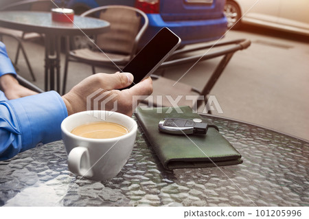 Cup of coffee and hand of man with a cellular telephone for Your advertisement text message 101205996