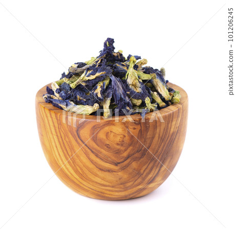 Butterfly pea flowers in wooden bowl, isolated on white background. Blue herbal tea. Clitoria Ternatea. 101206245
