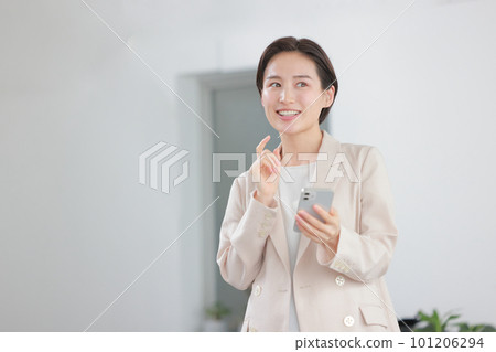 女商人 1 拿著智能手機，微笑著思考 101206294