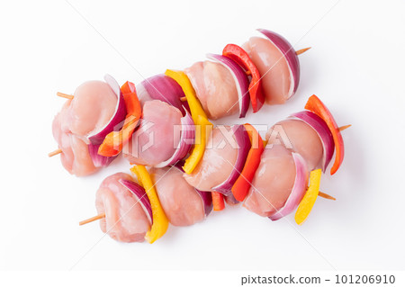 Raw chicken leg meat skewers with vegetables, peppers, onions, on a white background.Uncooked mixed meat skewer with peppers.Skewers with pieces of raw meat, red, yellow and green pepper.Top view. Raw chicken leg meat skewers with vegetables, peppers, onions, on a white background.Uncooked mixed meat skewer with peppers.Skewers with pieces of raw meat, red, yellow and green pepper.Top view. 101206910