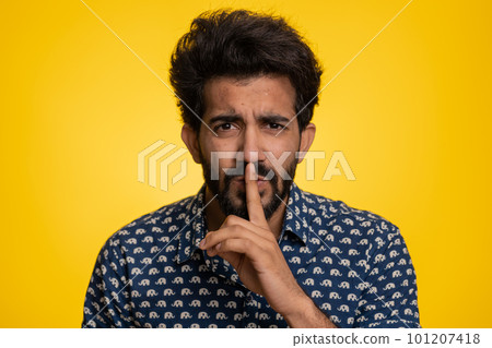 Young indian man presses finger to lips makes silence gesture sign do not tells secret, stop gossip Young indian man presses finger to lips makes silence gesture sign do not tells secret, stop gossip 101207418