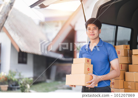 Smiling delivery asian man standing in front of his van. Portrait of courier delivering parcel package 101207869