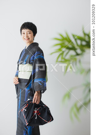 A woman in a kimono holding a wrapping cloth A woman in a kimono holding a wrapping cloth 101209329