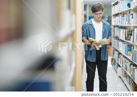 Student reading book at library. Student reading book at library. 101210254