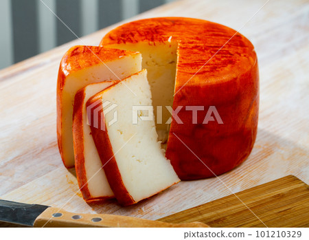 Tasty french goat cheese with pepper, slices at wooden desk 101210329