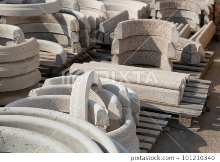 Pallets with stack of curbstones lying at warehouse 101210340