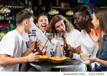 Excited football fans celebrating victory of favorite South Korean team in sports bar Excited football fans celebrating victory of favorite South Korean team in sports bar 101210485